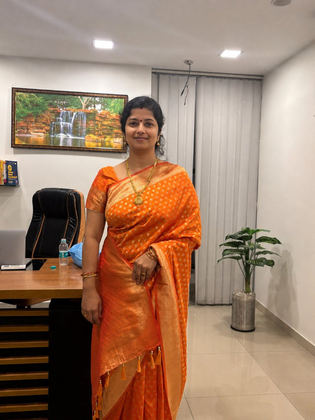 Khushi Reddy, Founder of Kunjaree Silks, in a handwoven orange silk saree at the Bellandur store