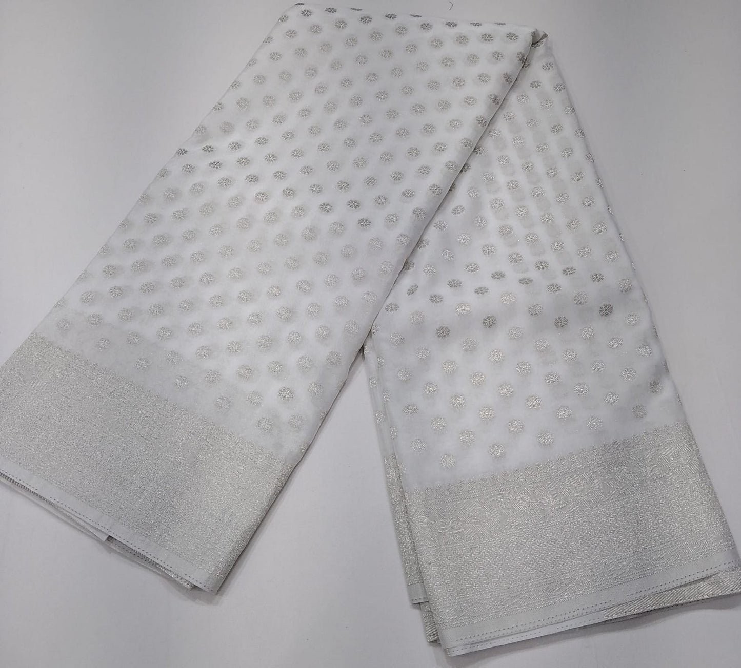 Elegant Pearl White Georgette Chinnon Saree with Silver Zari Buttas