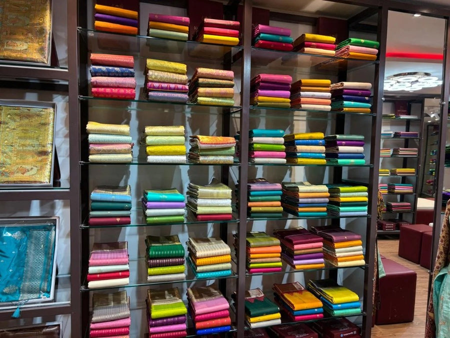 Kunjaree Silks showroom shelves stacked with pure silk and handloom sarees